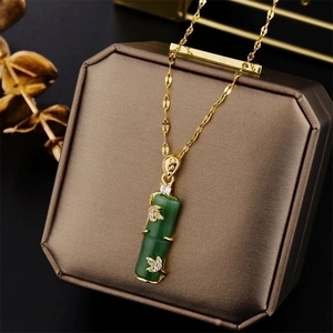 Golden titanium steel necklace with green bamboo joint pendant on brown jewelry box