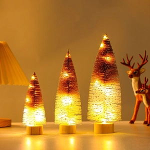 Close-up of three glowing Christmas trees with wooden bases and warm LED lighting