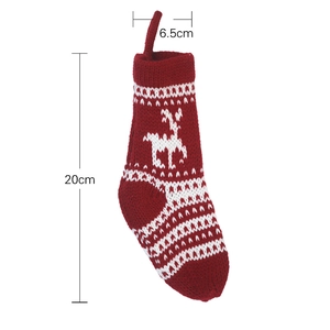 Classic red knitted Christmas stocking with white reindeer and snowflake patterns