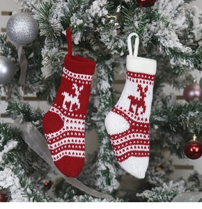 Détail de chaussettes de Noël tricotées rouges et blanches avec motif renne sur sapin