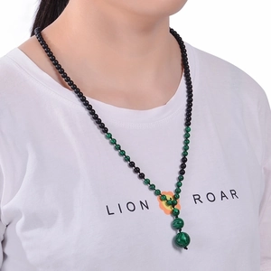Detailed view of Y-shaped beaded necklace with volcanic stones and tiger eye pendant