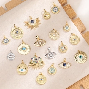 Detailed flat lay of gold Evil Eye charms with colorful zircons and blue enamel detail