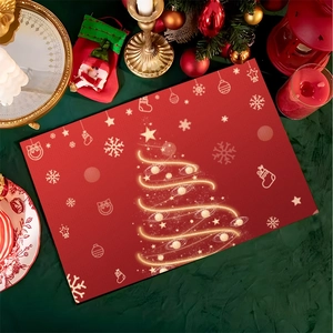 Detail view of red Christmas placemat featuring a golden line art tree and festive icons