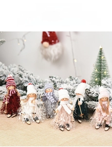 Close-up of wooden Christmas dolls with knitted hats and skis on a festive tabletop