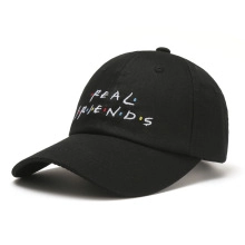 Close-up of Real Friends embroidery on a black cotton baseball cap in classic TV style