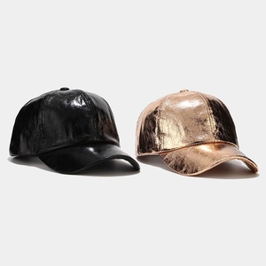 Close-up of metallic rose gold and black PU baseball caps with unique crinkled leather texture