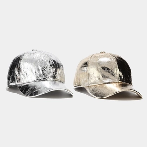 Detail of metallic pleated PU baseball caps in gold and silver with reflective finish
