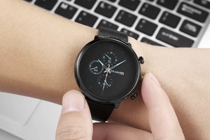 Close-up of black YOLAKO men's chronograph watch with stylish mesh strap on wrist
