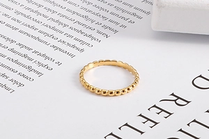 Macro detail of golden beaded texture ring on vintage paper background