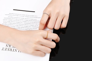 Close-up of minimalist beaded titanium steel rings in gold and silver on a model hand