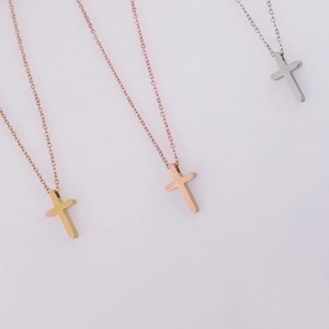 Detailed view of polished cross pendants in gold, silver, and rose gold on O-chains