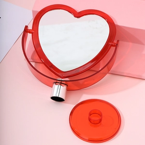 Red heart-shaped desktop makeup mirror with detachable base on pink background