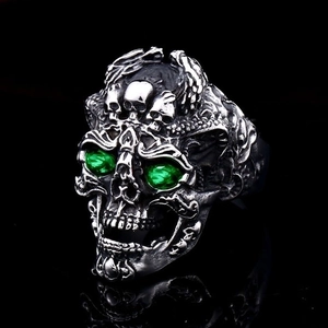 Detailed view of gothic skull ring with green gemstone eyes and vintage silver finish
