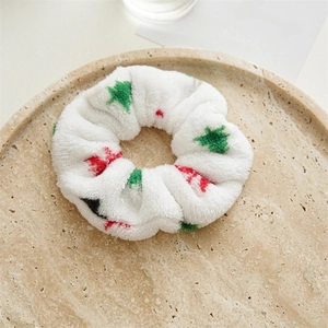 White velvet Christmas scrunchie with green trees and red snowflakes on a tray