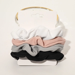 Set of four ribbed fabric scrunchies in white, pink, grey and black on display card