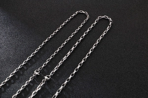 Detailed close-up of high-polish stainless steel box chain necklace links in silver