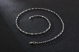 Detailed close-up of a silver stainless steel box chain necklace with lobster clasp