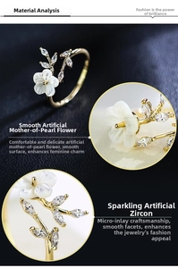 Close-up of golden flower ring featuring white shell petals and leaf-shaped zircons