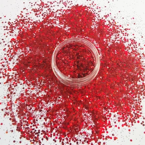 Sparkling red hexagonal nail glitter in clear jar with scattered shiny sequins