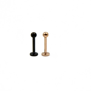 Pair of stainless steel labret studs in black and rose gold with flat back and ball top