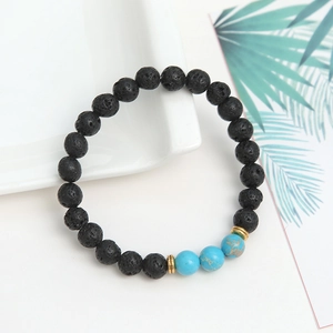 Macro detail of elastic bead bracelet with black lava stone and blue turquoise accents