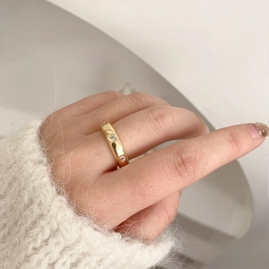 Anillo minimalista de latón chapado en oro con circonitas brillantes mostrado en la mano