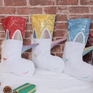 Detailed view of three unicorn Christmas stockings with colorful sequins and plush fabric