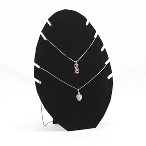 Macro detail of black velvet necklace display stand with flame leaf shape showing pendants