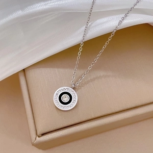 Macro view of silver titanium steel necklace with crystal circle and black enamel inlay