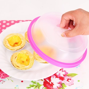 Pink stackable food preservation cover showing easy lifting over a plate of tart shells