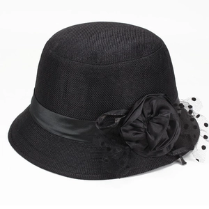 Detail eines schwarzen Sonnenhutes mit Webstruktur, Satinband, Stoffblume und Polka-Dot-Netz