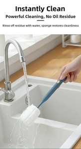 Close-up of a long-handled sponge cup brush being rinsed under running water in a sink