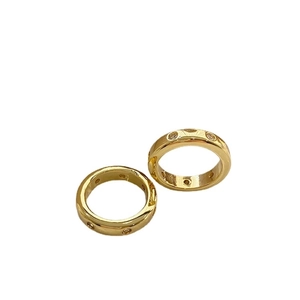 Elegante anillo de latón chapado en oro con circonitas brillantes sobre fondo blanco