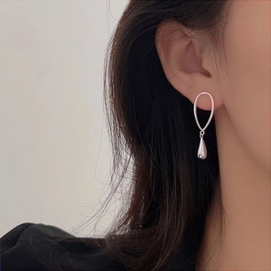 Elegant S925 sterling silver water-drop pendant earrings worn on a model's ear