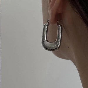 Minimalist silver U-shaped braided metal earrings with textured ribbed geometric design