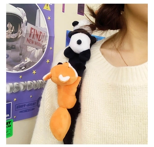Close-up of cute plush panda and fox shoulder brooches worn on a white sweater