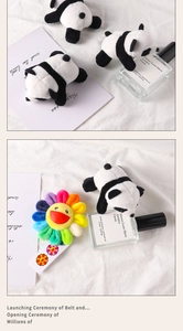 Detail of plush panda brooch and colorful sunflower plushie on white fabric