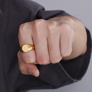 Close-up of a men's polished 18K gold plated stainless steel signet ring on a pinky finger