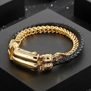 Macro shot of gold stainless steel clasp on black woven leather bracelet on gift box
