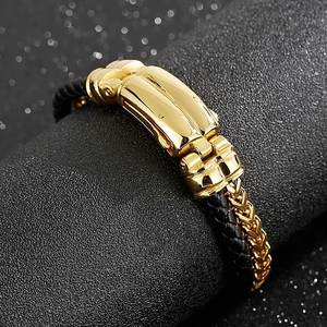 Detail of woven black leather and golden wheat chain bracelet with spring metal clasp