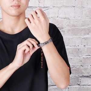 Detailansicht eines geflochtenen Lederarmbands für Herren mit Punk-Metallverschluss