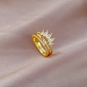 Adjustable gold crown ring with LOVE engraving and marquise diamonds on silk fabric