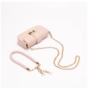 Detail of pink croc-pattern bag with gold metal hardware and detachable hand strap