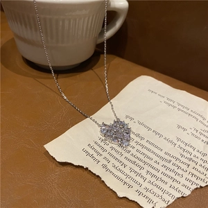 Close-up of sparkling heart pendant with zircon inlay on decorative vintage paper