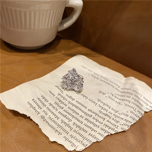 Macro detail of silver heart necklace pendant with sparkling white zircons on vintage book