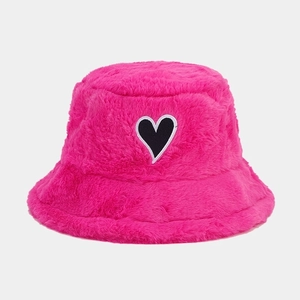 Detailaufnahme des flauschigen rosa Plüsch-Anglerhuts mit kontrastierendem Herz-Patch