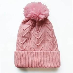 Rosafarbene Strickmütze für Damen mit großem Pompon und eleganten Perlenverzierungen