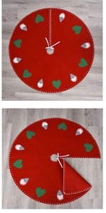 Detalle del pie de árbol de Navidad rojo con apliques de gnomos y corazones rojos