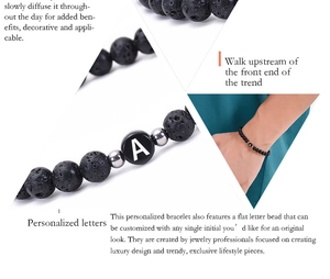 Detail view of 6mm black volcanic stone bracelet with a custom letter A bead and silver spacers