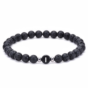 Macro detail of natural lava stone bracelet with silver spacers and letter I bead
